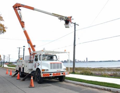 photo of a service truck and crew working on a power line